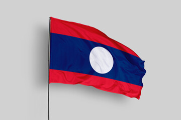 Laos flag isolated on the blue sky background. close up waving flag of Laos. flag symbols of Laos. Concept of Laos.