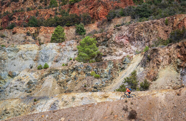 nice active woman riding her electric mountain bike in the abandoned Iron Ore mines of Calamite peninsula on the Island of Elba, Tuscan Archipelago, Tuscany,Italy 
