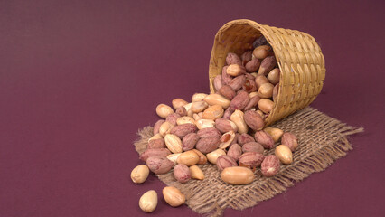 Groundnuts in wooden bowl isolated on plane background, salted roasted peeled nuts, top view