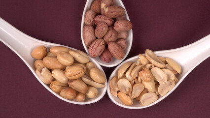 Groundnuts in wooden bowl isolated on plane background, salted roasted peeled nuts, top view
