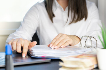 Hands of a financial worker in a white shirt working with documents close-up.