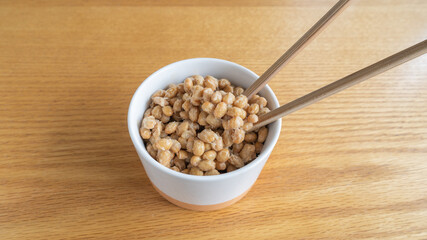 日本の納豆と生大豆。納豆を箸で混ぜる。	