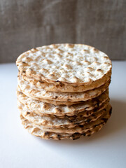 Stack of round crispbreads on white/textile background