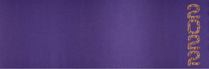 Happy new year 2022. Numbers 2022 with a pinecone texture on an isolated purple background. New year's holiday concept; copyspace; banner