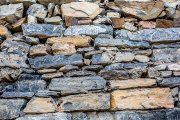 Stone antique old wall as a background or texture. Vintage background of a fortress wall in loft and grunge style with place for text and copy space.