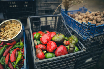 Shallow depth of field (selective focus) image with vegetables (red and green peppers, dill, nuts, green tomatoes) sold by a Romanian man from his garden in a rural area.