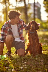 Young male owner picking up dog's feces; Dog owner lifestyle