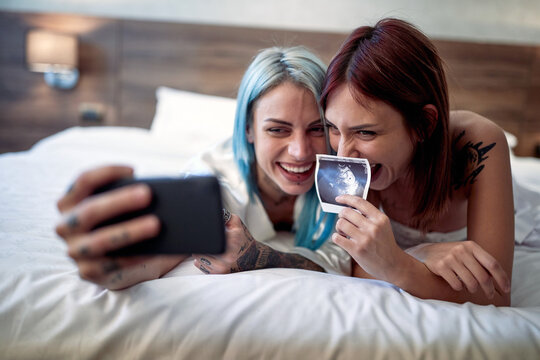 Joyful lesbian couple announcing a pregnancy test results