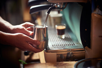 A milk in the container being boiled in the espresso apparatus by a barman. Coffee, beverage, bar
