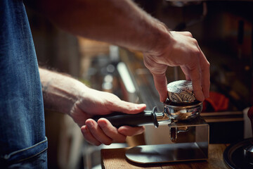 A barman behind the bar is preparing an espresso beverage. Coffee, beverage, bar