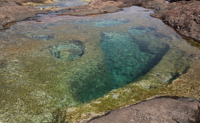 Gran Canaria, calm rock pools under steep cliffs of the north coast are 
separated from the ocean by volcanic rocks of platform  constructed by old lava flows
Punta de Galdar area