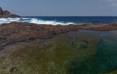 Gran Canaria, calm rock pools under steep cliffs of the north coast are 
separated from the ocean by volcanic rocks of platform  constructed by old lava flows
Punta de Galdar area