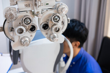 Selective focus at Optometrist face. While doctor using medical equipment and subjective refraction to  examine eye visual system of elder patient women with professional machine before made glasses.