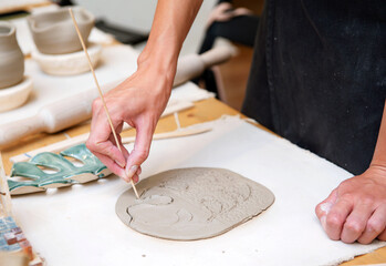 Fototapeta na wymiar Woman hands doing pottery decor table