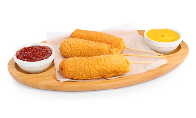 Delicious deep fried corn dogs with board and sauces isolated on white