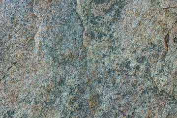 Natural stone texture. Granite surface of sheer cliff. Solid rock close-up