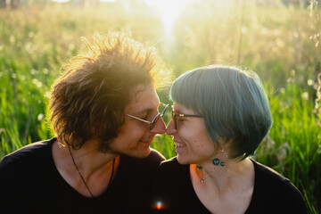 Beautiful couple of  young man and young woman flirt outdoor  in  park  during golden hour.