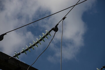 Power lines on background of blue sky close-up. Electric hub on pole. Electricity equipment with...