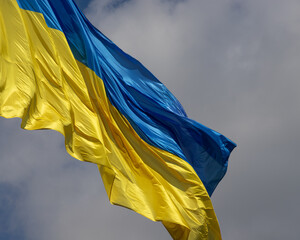 Ukraine flag waving on the wind against the blue sky