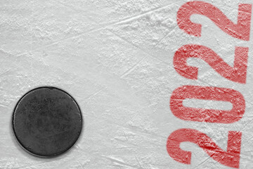Fragment of the ice rink with a red inscription and a hockey puck