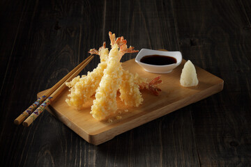 Deep fried Shrimp Tempura,traditional japanese food on a wooden board on dark wooden background.