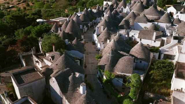 Aerial view of trulli of alberobello town in Italy. drone fly over old town buildings at sunrise
