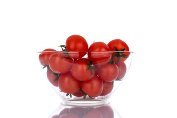 Several red organic tomatoes with glassware, close-up, isolated on white.