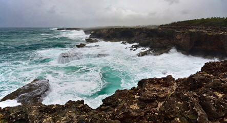 Rough ocean waves crashing against the rocky cliffs of North Point, Barbados, Caribbean
