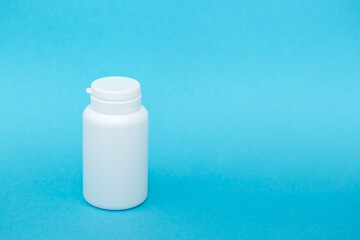 White different medical or cosmetic jars on a blue background as a concept of cosmetology of medecine and treatment