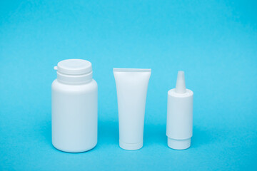 White different medical or cosmetic jars on a blue background as a concept of cosmetology of medecine and treatment