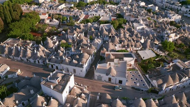 Aerial view of trulli of alberobello town in Italy. drone fly over old town buildings at sunrise
