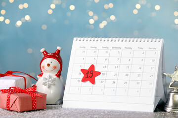 Saint Nicholas Day. Calendar with marked date December 19, gift boxes and snowman figure on table...