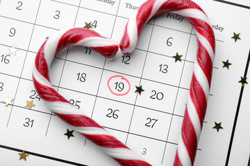 Saint Nicholas Day. Heart shape frame of candy canes and confetti on calendar with marked date...