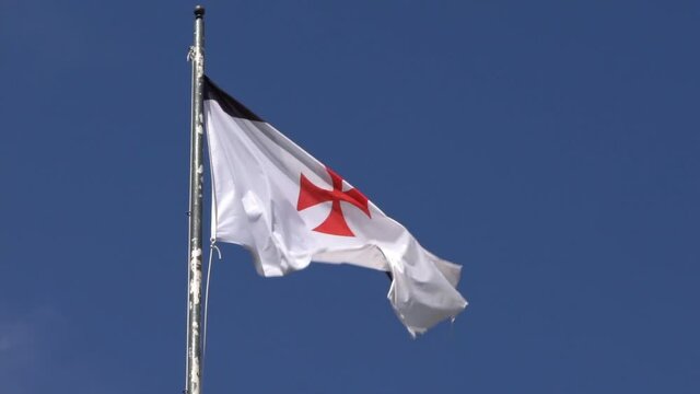 Close up flag of banner the knights templars at castle medieval in Jerez de los Caballeros Spain. The Catholic military order was a poor fellow soldiers of christ and temple of solomon. -Dan