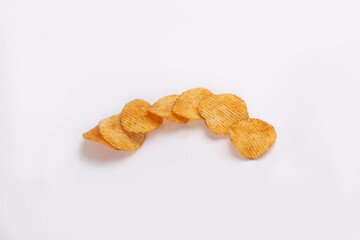 Bowl of tasty ridged potato chips on white background | top angle beautiful focused
