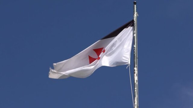 Slow Motion of flag banner the knights templars at castle medieval in Jerez de los Caballeros Spain. The Catholic military order was a poor fellow soldiers of christ and temple of solomon. -Dan