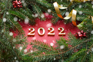 Figures for the new year 2022. Christmas 2022. Fir branches and Christmas toys on a red background. High quality photo