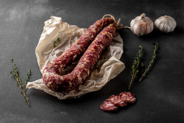 red dry homemade sausage on a dark background