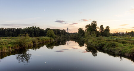 River in a city park. Colorful Summer Sunset. Colony Farm Regional Park, Port Coquitlam, Vancouver, British Columbia, Canada.