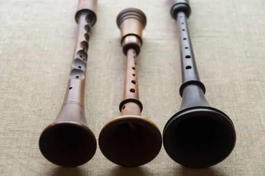 Reconstruction of ancient folk woodwind musical instruments - zhaleika and two schalmeis, located on a gray linen cloth