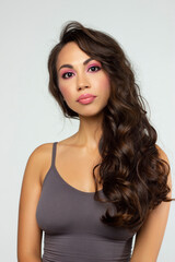 Fototapeta premium Beautiful brunet model woman face with brown eyes and perfect make-up . Portrait of beauty young brunet girl with pink lips. Female face with clear skin close-up. Skincare