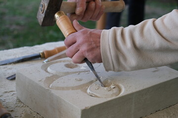 Artisan de la rénovation des chateaux taillant une fleur de lys
