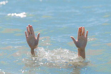 A hands from under the water of a drowning girl, help and urgent rescue of a person during a...