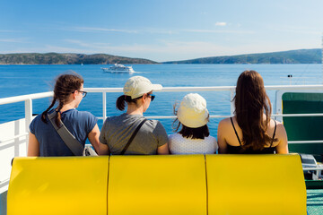 Family - mother with three daughters - on the ferry. The beginning of vacation - sea journey concept