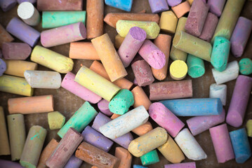 Сolorful children's crayons are scattered on the table to draw