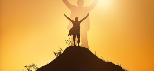 Leadership and achievement people concept. Silhouette of man on mountain top over sunset sky background. Hands up photo