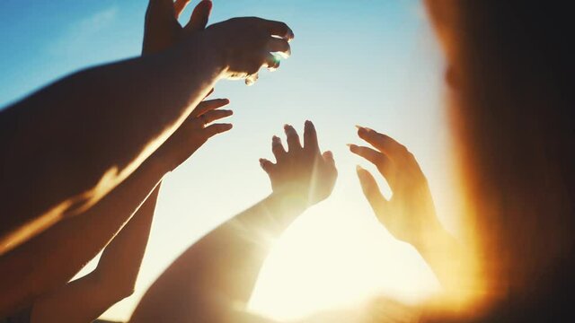 group of cheerful people together party pulling hands to the sun on the beach. teamwork. silhouette people party dancing recreation holiday. people music. pull their hands fun up. religion concept