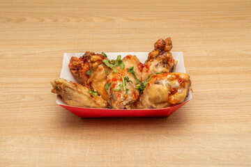 Portion of chicken wings marinated in Thai sauce, fried in olive oil with parsley