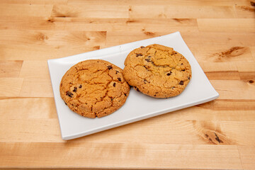 Dark chocolate chip oatmeal cookies on light pine table