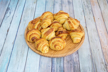 Bamboo wood plate filled with mini butter croissants for a snack